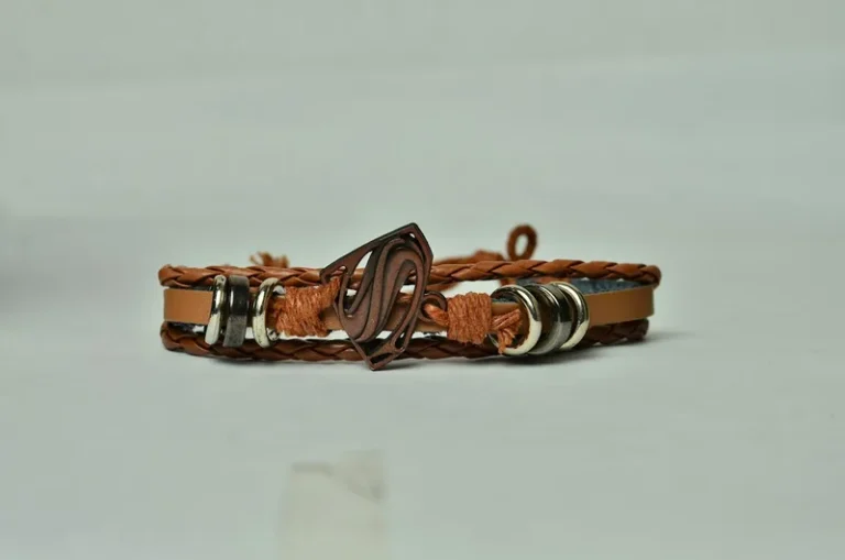 Pulsera trenzada de cuero marrón con adornos metálicos